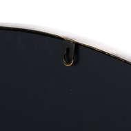 Close-up of a black wall mirror with gold hanging hook and rounded edge detail