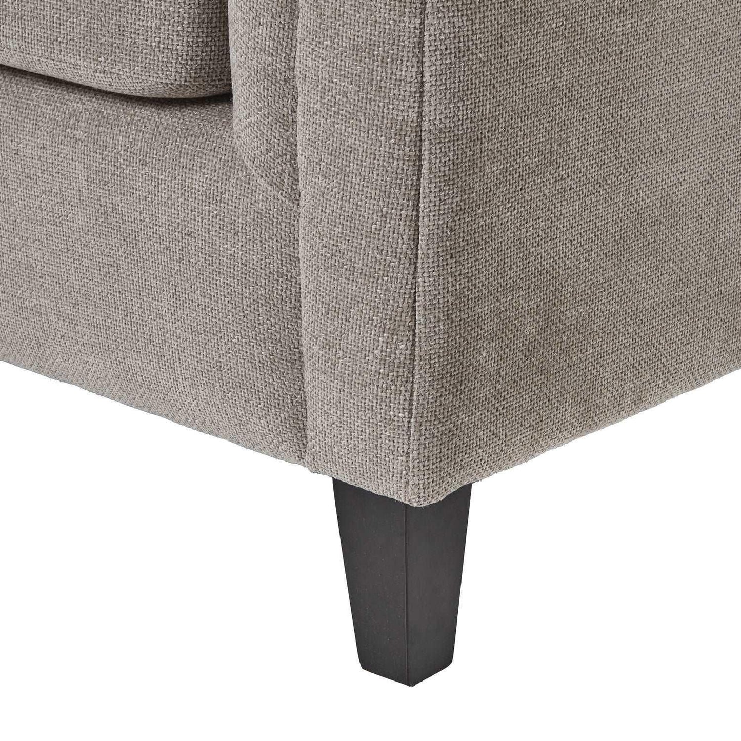 Close-up of grey textured fabric sofa corner with dark wooden leg, luxury furniture detail