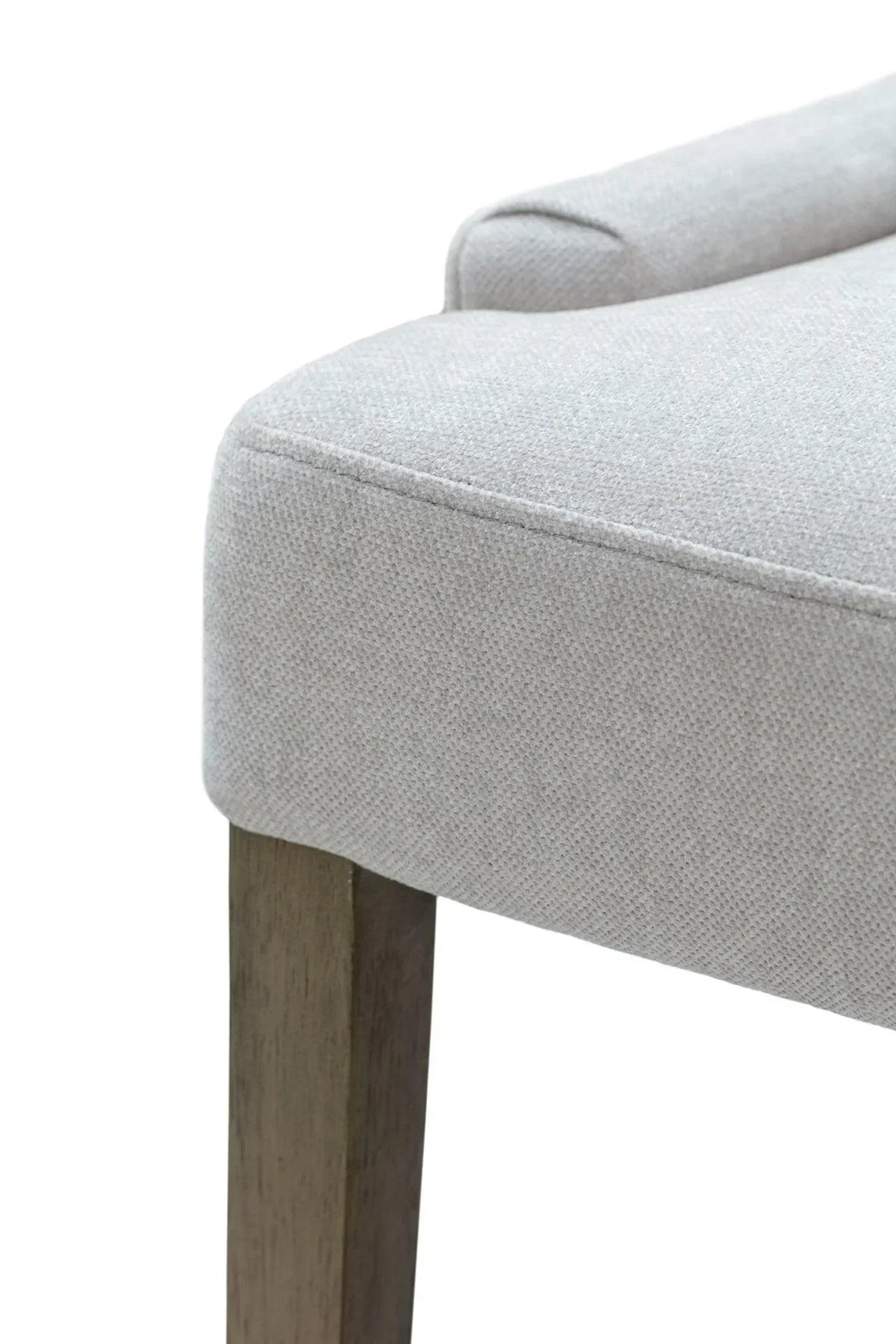 Close-up of upholstered chair seat in light grey fabric with wooden leg