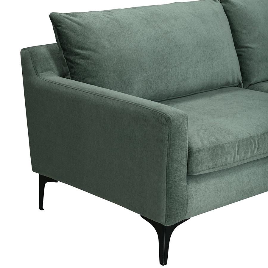 Modern green velvet sofa with slim black metal legs and plush cushions