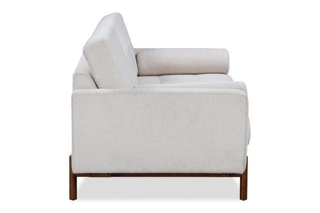 Side view of a modern light beige upholstered sofa with wooden legs