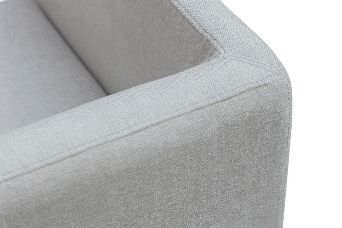 Close-up of a modern light grey fabric armchair with clean minimalist lines