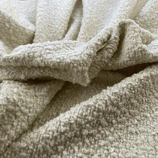 Ivory soft textured upholstery fabric with a subtle boucle pattern, perfect for luxury furniture.