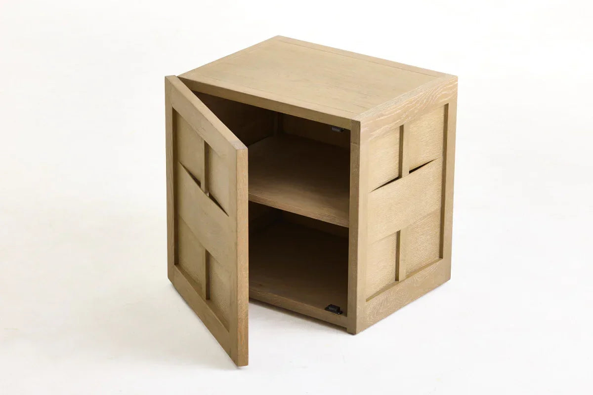 Light oak wooden side table with open cabinet door and geometric panel design