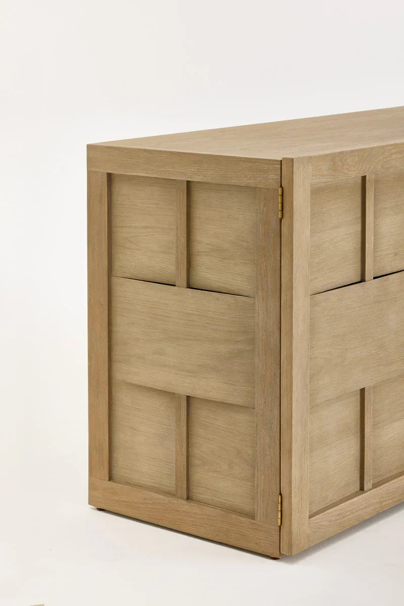 Modern oak wood sideboard with panelled design and brass hinges on white background
