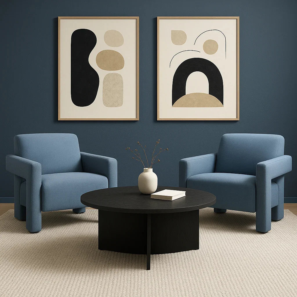 Modern dark round coffee table with minimalist vase, flanked by two blue armchairs in a stylish living room