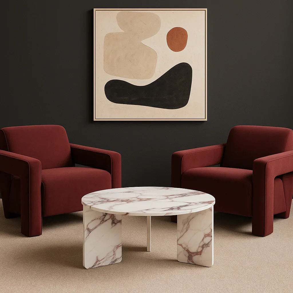 Burgundy velvet armchairs and round marble coffee table in modern living room setting